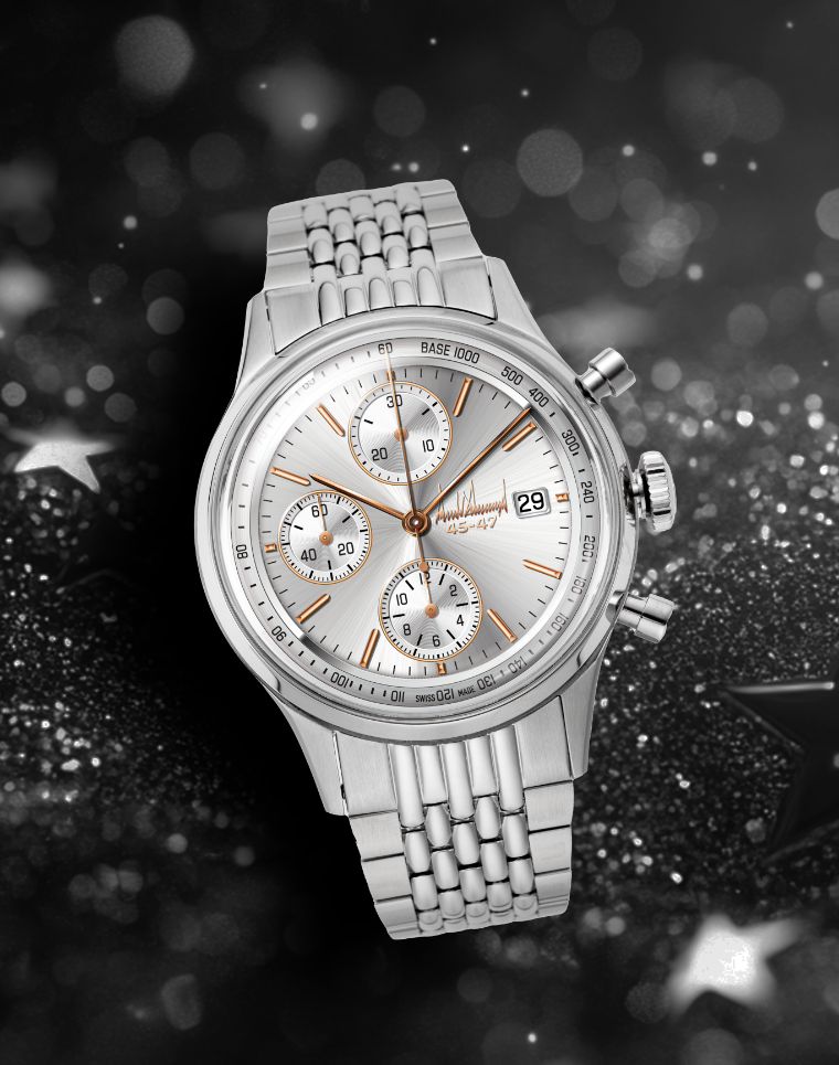Silver chronograph wristwatch with metal bracelet on glittery black background with star accents.