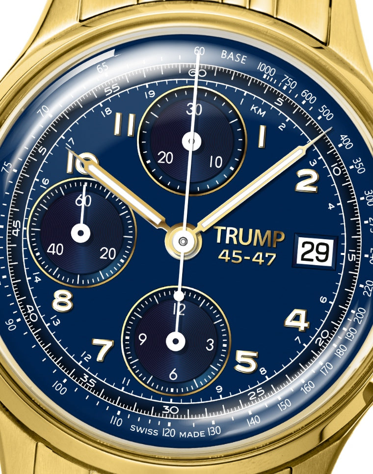 Gold Trump 45-47 chronograph watch with blue dial, subdials, date window, and tachymeter scale.