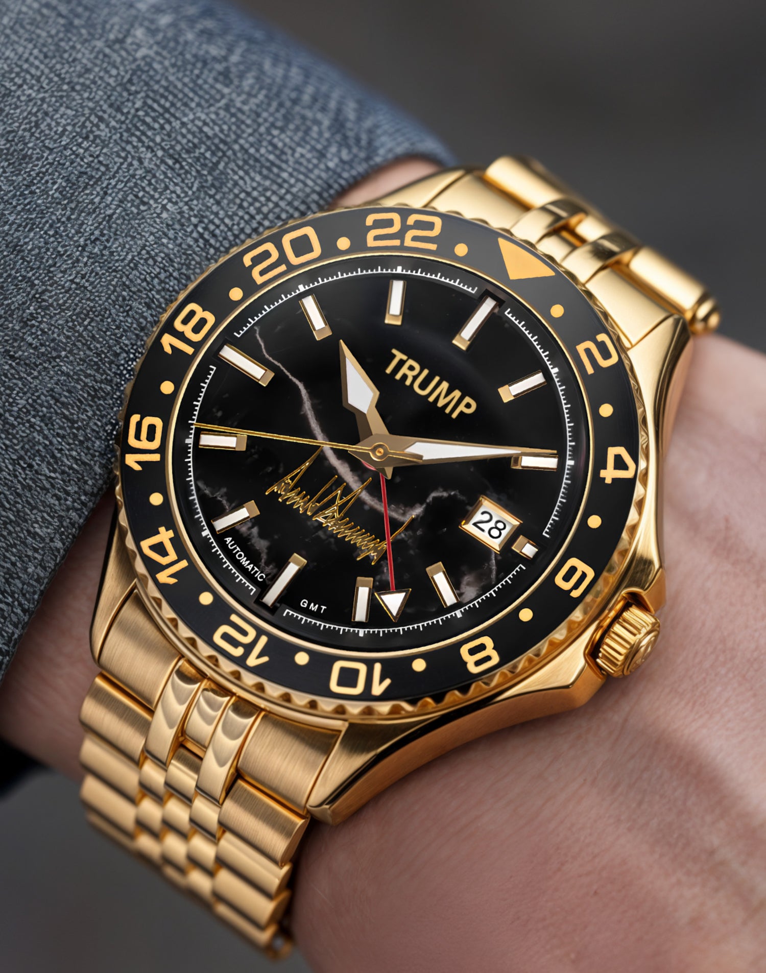 Gold Trump-branded wristwatch with black dial, date display, and signature detailing.