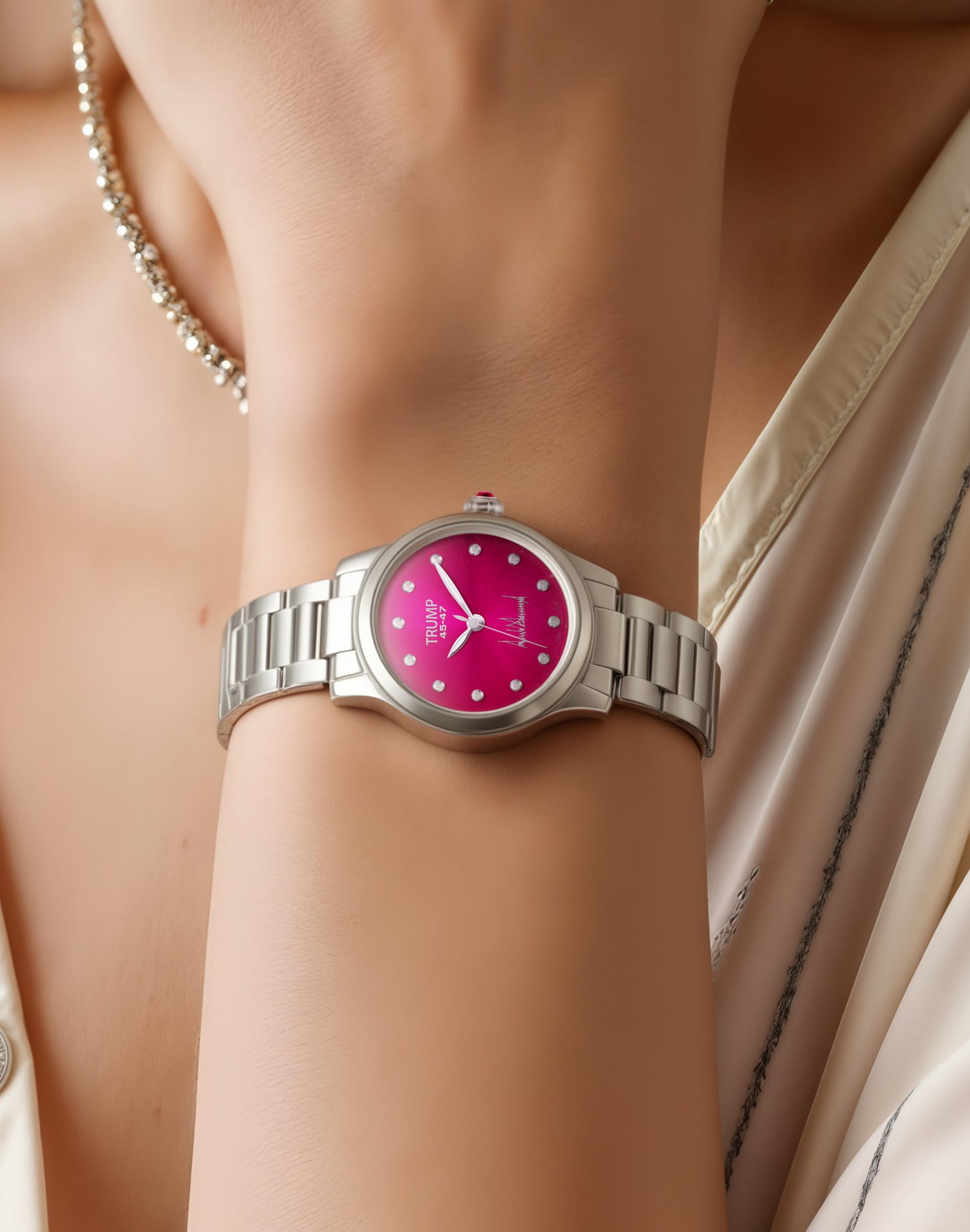Silver wristwatch with pink dial and diamond markers worn on a woman's wrist in elegant attire.