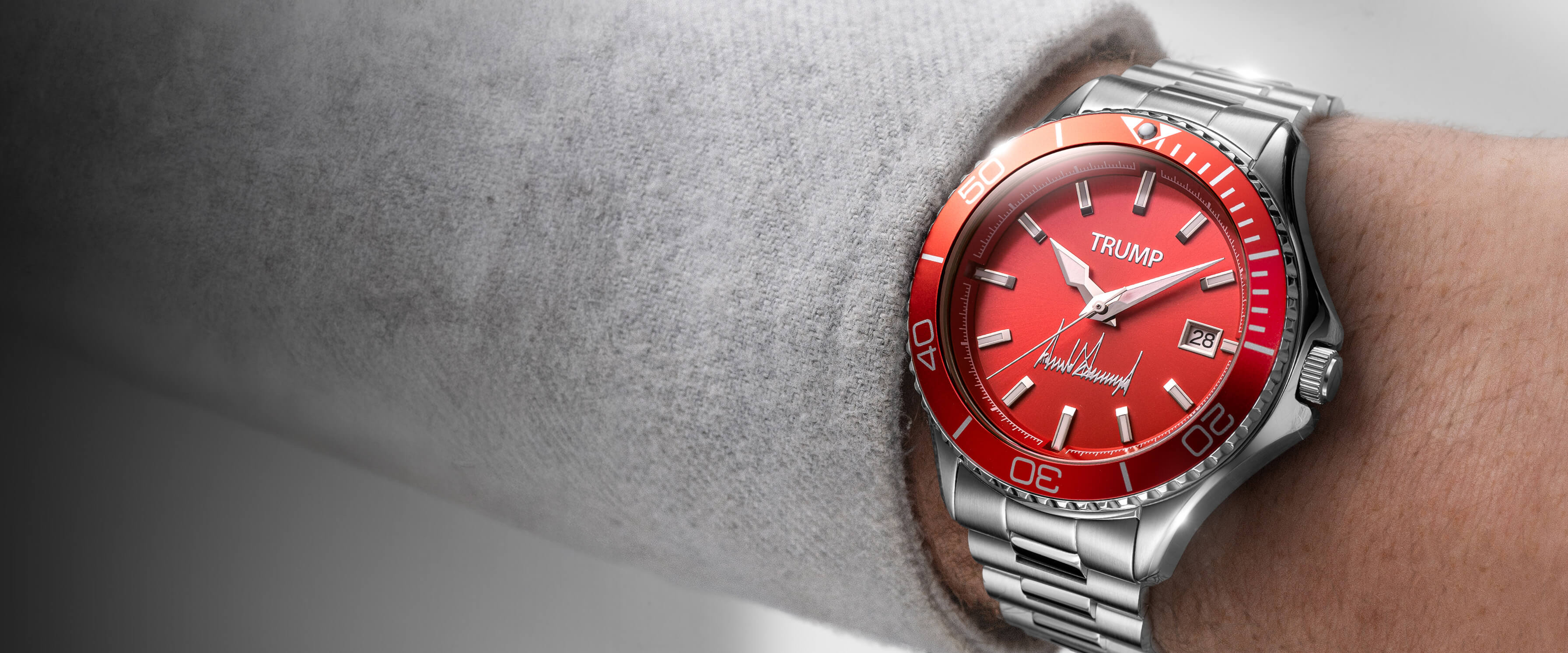 Red dial Trump wristwatch with silver metal band and date display worn on a person's wrist.