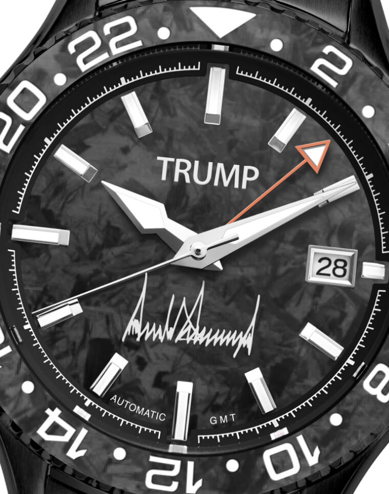 Black Trump GMT automatic watch with carbon fiber dial, date window, and signature detail.