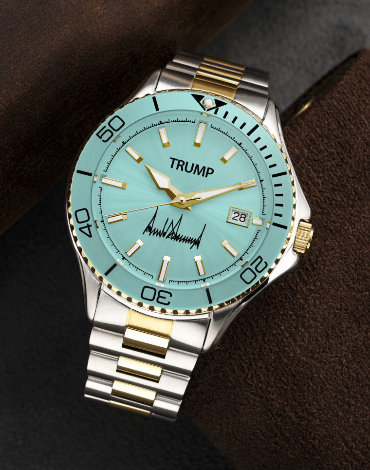 Two-tone Trump wristwatch with aqua dial, gold accents, date display, and signature on face.